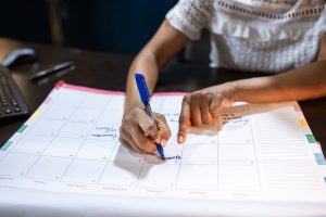 Persona planificando la jornada laboral en un calendario, en referencia a la jornada de 37,5 horas