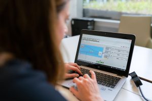 Profesional utilizando un software de control horario en su ordenador portátil